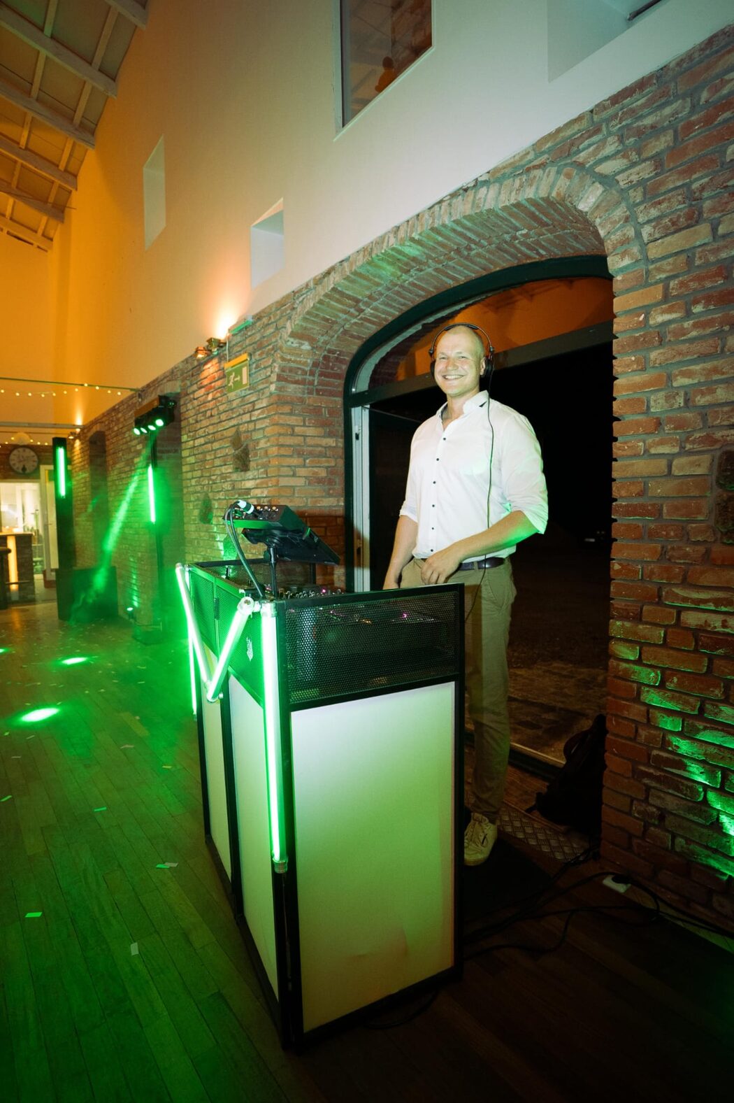 DJ Jonathan von JC Music am beleuchteten Pult bei einer Hochzeit mit grünen Lichteffekten