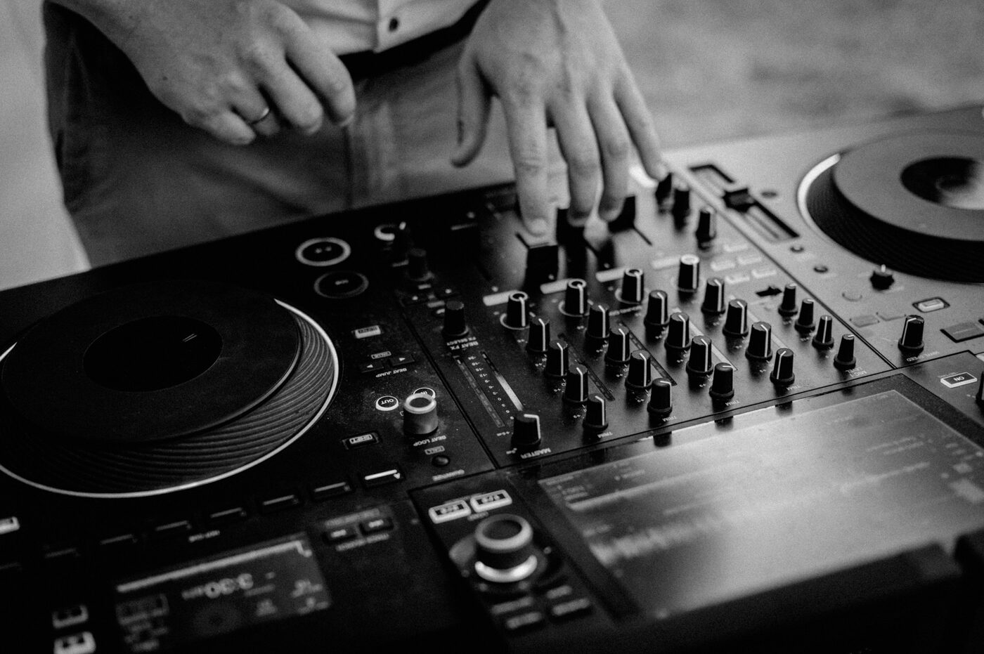 Hände von DJ Jonathan am Mischpult – Schwarz-Weiß-Aufnahme
