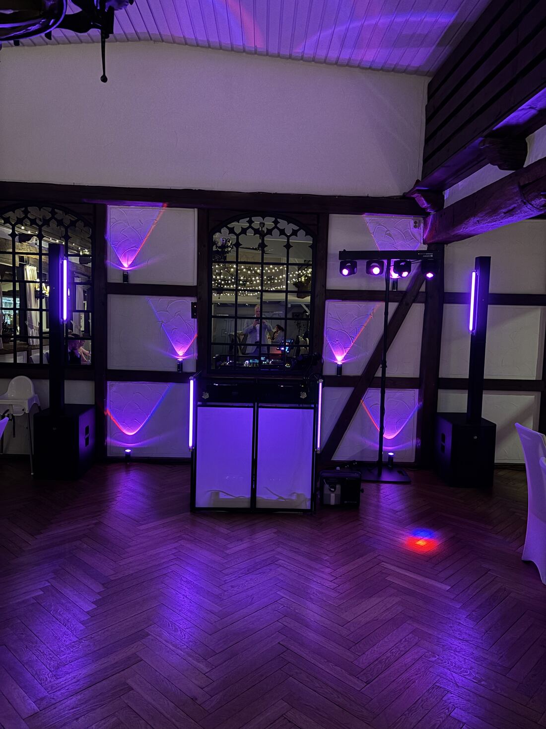 Stimmungsvoll beleuchtetes DJ-Setup mit LED-Säulen in violett